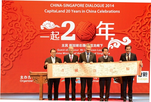 五位嘉宾展示象征中新友谊的团花印章盖的签字卷轴