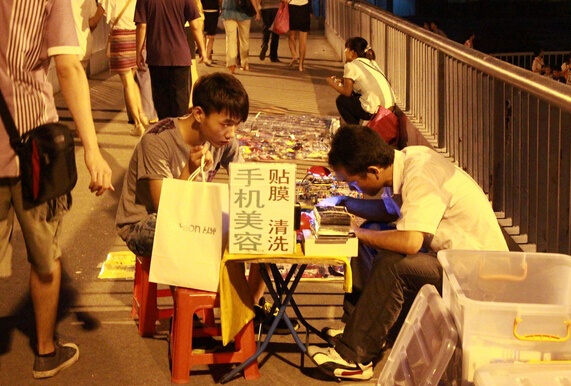如果说,摆摊贴膜成本低,收入高,那最大的辛苦就是要在室外,晚上的灯光